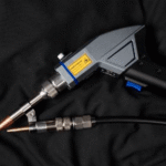 Close-up of a welding tool on black fabric.