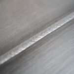 Close-up of a metallic surface with a weld seam.