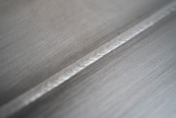 Close-up of a metallic surface with a weld seam.