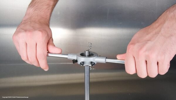 Hands using a tool to manipulate a metal object