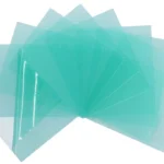 Stack of translucent green plastic sheets.