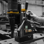 Person using a drill on a workbench.