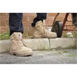 Close-up of tan work boots on pavement.