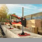 Two clamps securing wooden beams in construction.